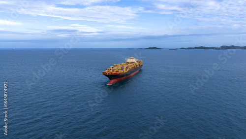 Top view Cargo Container ship with contrail in the ocean ship carrying container and running for import export concept technology freight shipping by ship.