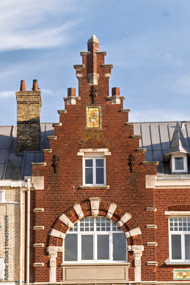 Fototapeta premium ornate historic townhouses with distinct architectural styles. The scene captures the charm of coastal architecture in Dunkirk, France