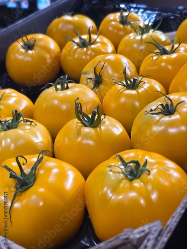 yellow tomatoes big on the counter in the store background