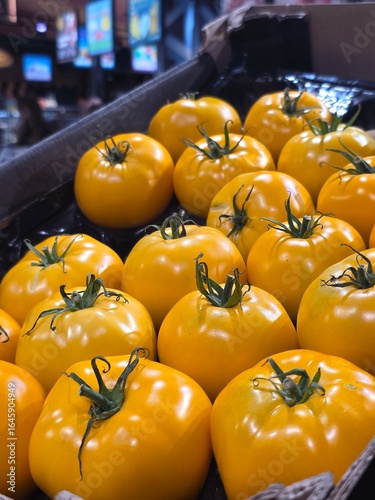 yellow tomatoes big on the counter in the store background