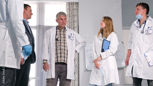 Photos A group of doctors discusses the patient's condition and upcoming heart surgery with a relative