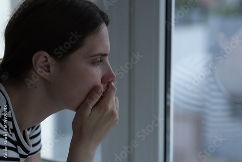 Sad young woman near window at home, space for text Free Download Sad young woman near window at home, space for text - GFXLoad