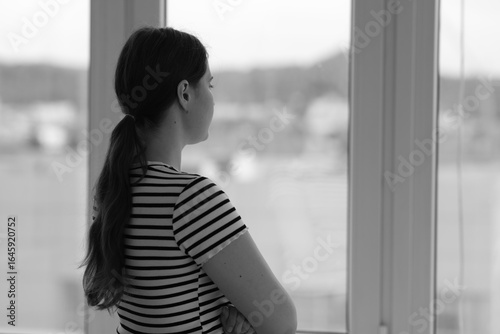 Sad young woman near window at home, back view and space for text. Black and white effect Free Download Sad young woman near window at home, back view and space for text. Black and white effect - GFXLoad