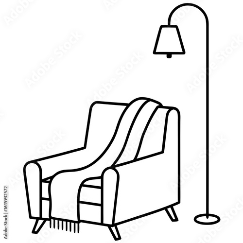Cozy reading corner with armchair, floor lamp, and blanket draped over the side