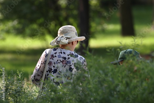 A woman in a hat and a boy are relaxing in a city park