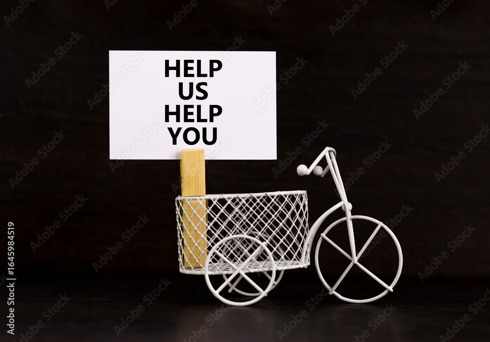 Help you symbol. Concept words phrase Help us help you on beautiful white paper on wooden clothespin. Miniature bicycle. Beautiful black paper background. Business Help you concept. Copy space. Help you symbol. Concept words phrase Help us help you on beautiful white paper on wooden clothespin. Miniature bicycle. Beautiful black paper background. Business Help you concept. Copy space.