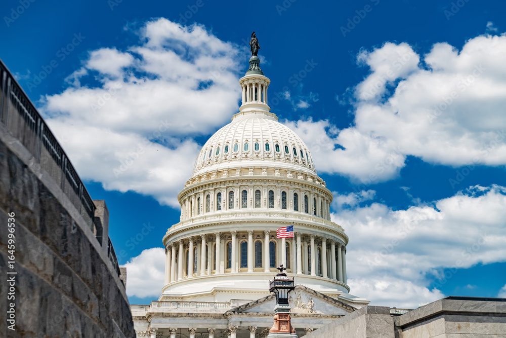 Obraz premium The US Capitol Dome under a Cloudy Blue Sky. Symbol of American Democracy.