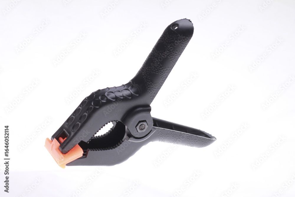 Obraz premium Black plastic spring clamp isolated on white background.
