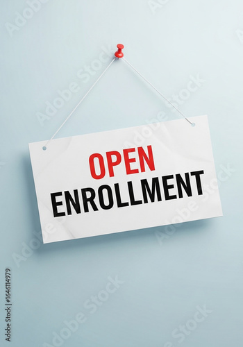 Photo of a sign on a blue wall announces the open enrollment period for employee health insurance benefits