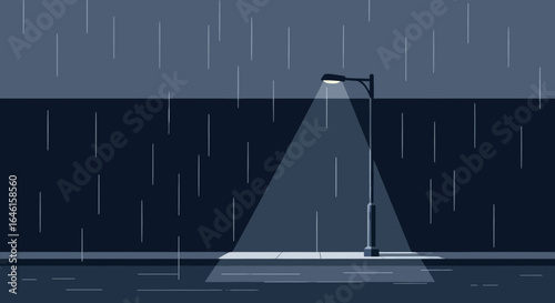 Monochromatic rainy night scene with street light illuminating sidewalk and wall