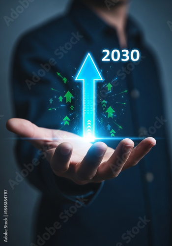 Photo of a persons hand holding a digital arrow pointing upwards with the year 2030 representing future growth and success