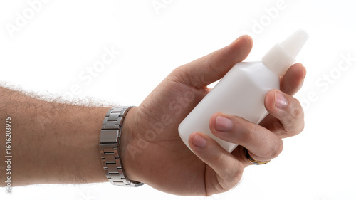 Canvas-taulu Hand holding a small white bottle with a nozzle against a plain background durin