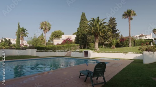Empty swimming pool with palm trees and landscaped gardens, Algarve, Portugal