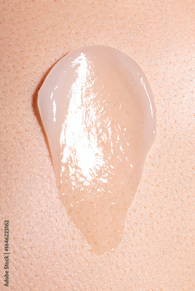 Fototapeta premium swatch of white cream on skin background, macro texture of the skin on which the cream is applied