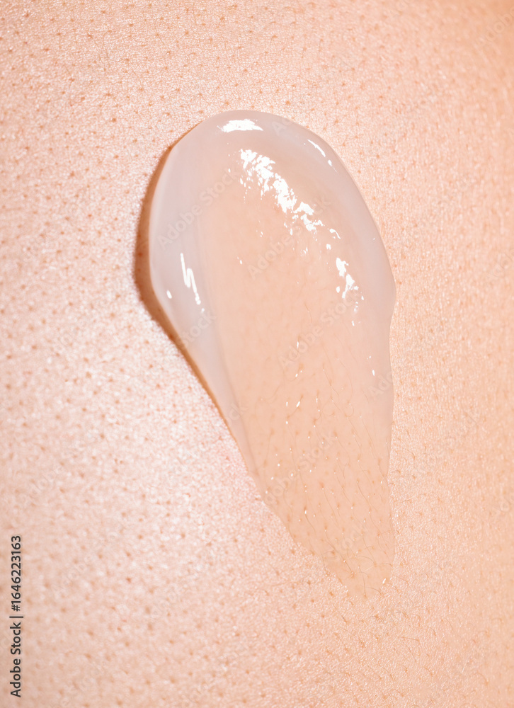 Fototapeta premium swatch of white cream on skin background, macro texture of the skin on which the cream is applied