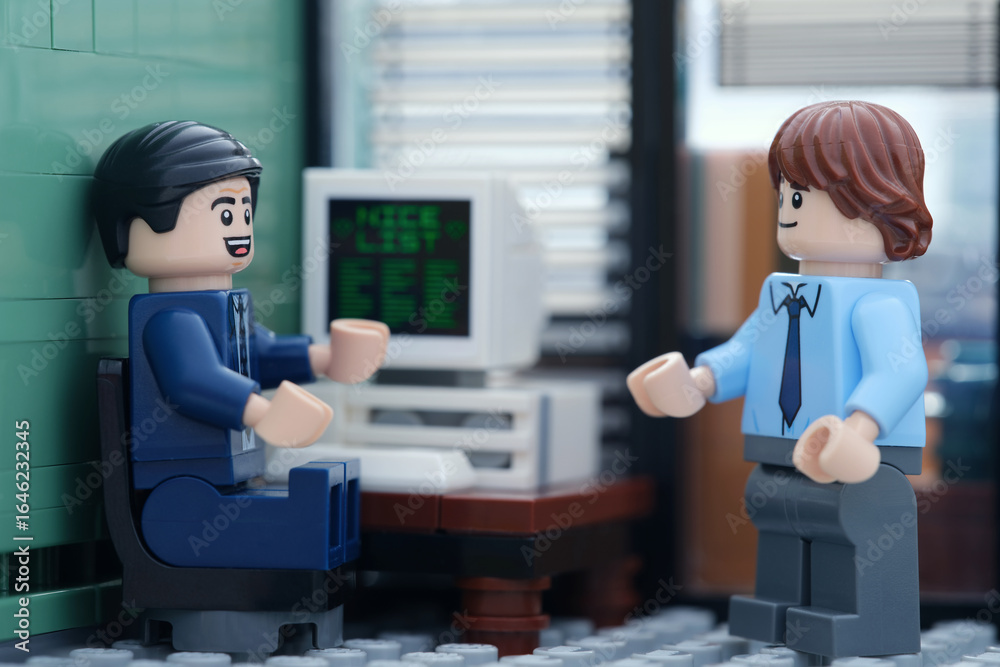 Obraz premium Tambov, Russian Federation - August 13, 2025 A Happy Lego businessperson minifigure sitting behind a computer and talking with another Lego businessperson minifigure.