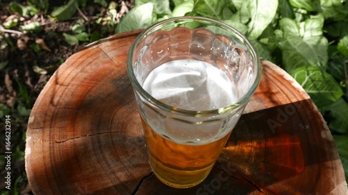 A shaky POV of someone placing a glass of beer on the table. A beer on the table. 