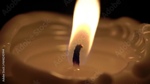 Burning Candle: A close-up shot of a lit candle flame dances elegantly against a dark backdrop, casting a warm glow. It embodies the tranquil, cozy, and romantic essence.