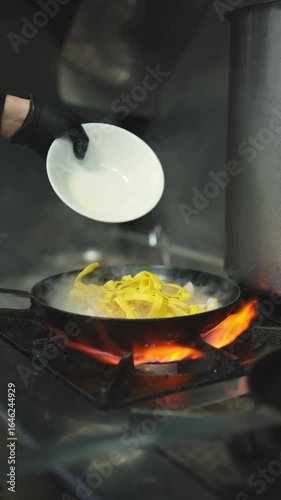 Pasta is thrown into a hot frying pan