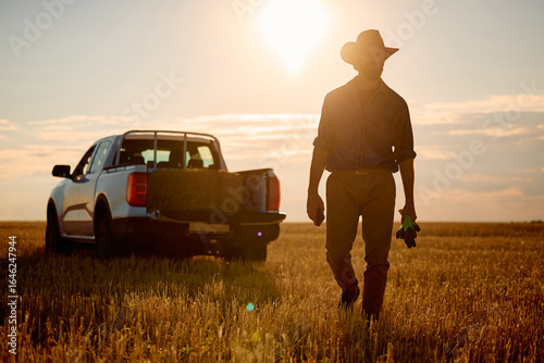 Obraz na plátně Full length of farmer working in field at sunset.