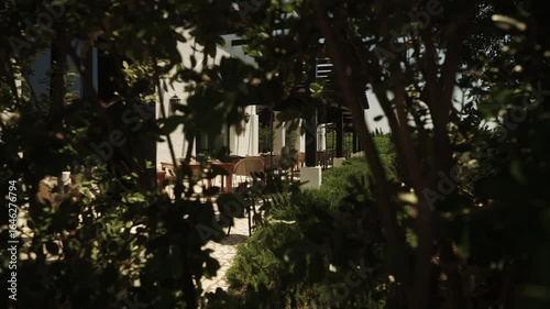 Outdoor terrace seating viewed through garden foliage in Portugal