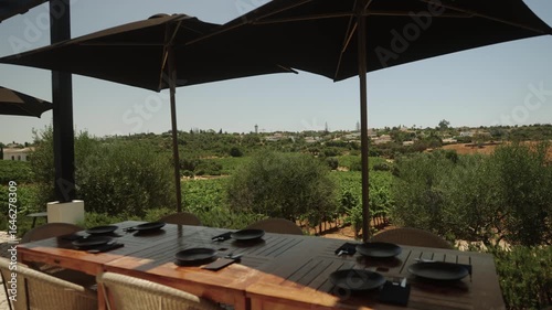 Outdoor dining table with vineyard view under large umbrellas in Algarve, Portugal