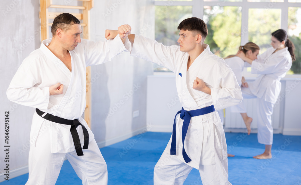 Obraz premium Athletes sparring during karate classes in the gym