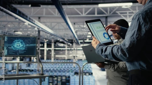 Wallpaper Mural Close up of data center employee checking infrastructure diagnostics graphs on tablet screen. IT specialist on industrial platform in server room examining data charts during system audit, camera A Torontodigital.ca