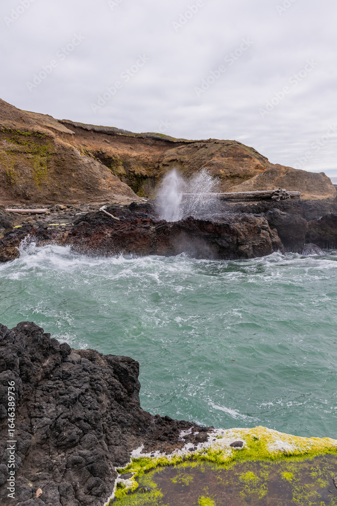 Fototapeta premium Cliffs with water spouting up from ocean