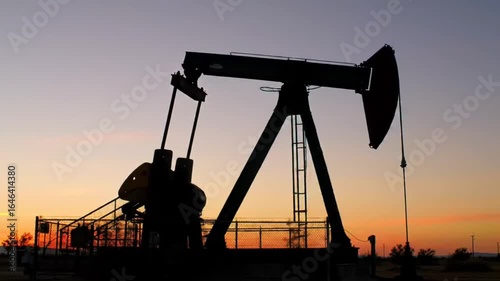 Silhouette of an Oil Pump Jack Against a Sunset Sky  Energy  Industry.