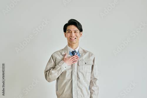 Naklejka 胸に手を当てる作業服姿の若い男性
