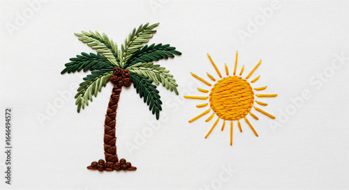 Embroidery of a palm tree and sun on white fabric.