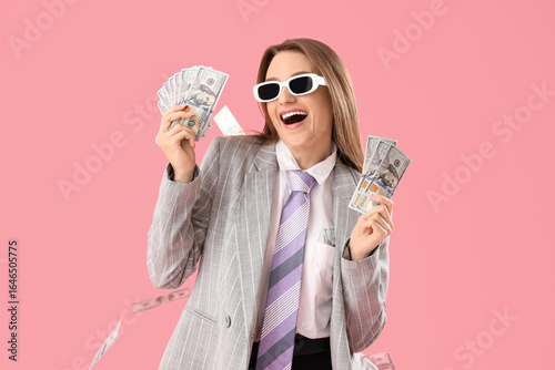 Foto Funny young businesswoman with money on pink background