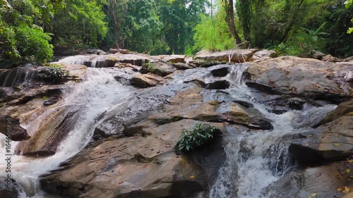 Beautiful waterfall in a tropical forest, Water stream flowing over rocks in a national park, The serene beauty of a jungle creek