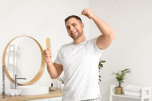 Young man with comb using s...