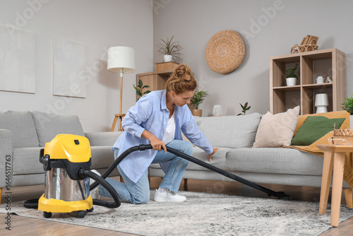 Mature woman with vacuum cleaner cleaning carpet at home