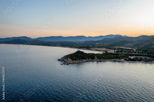 Aerial drone view of Capo Ferrato in the calm sea at sunset, wit