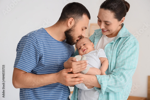 Happy young parents holding...
