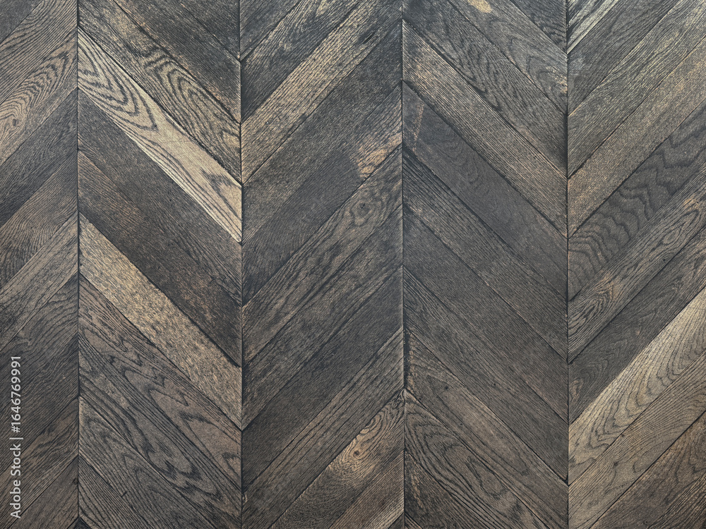Obraz premium Dark wood flooring in chevron pattern. Dark grey oak wood in inverted chevron shape arrangement. Seamless background texture.