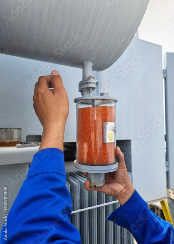 Fotografía The transformer preventive maintenance, the orange silica gel breather replacement by electrician
