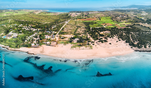 Fototapeta Naklejka Na Ścianę i Meble -  Aerial view of waves reaching a beautiful beach with turquoise water and golden sand on a sunny summer day