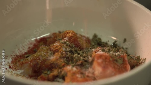 preparing food in the kitchen. Adding salt for marination.