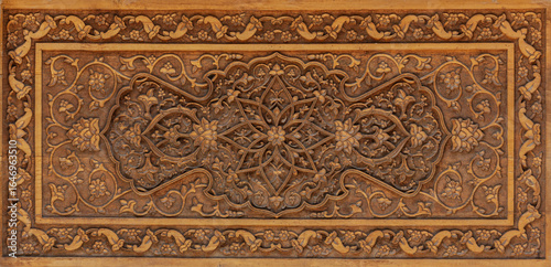 Traditional Uzbek wood carving with intricate floral and geometric patterns in oriental design