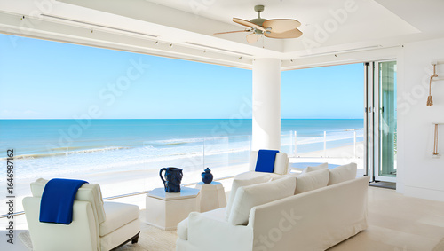 Cozy living room with white sofa and chairs, ocean views from large windows in Palm Beach, Florida, coastal style, luxury design, and blue accents.
