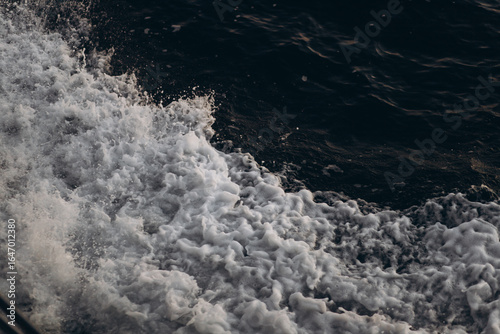 Φωτογραφία A close-up, abstract view of churning sea foam and waves, showing the dynamic texture and movement of the ocean water