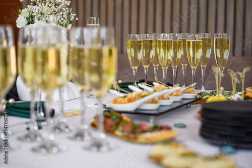glasses of champagne on a white table in a banquet hall.