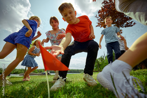 Photos Children energetically engage in a game of capture the flag beneath a bright sky