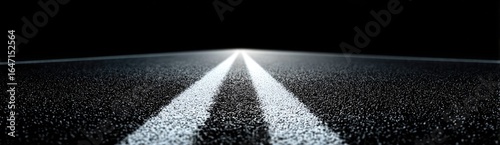 Dark asphalt road with two white lines stretching into the distance