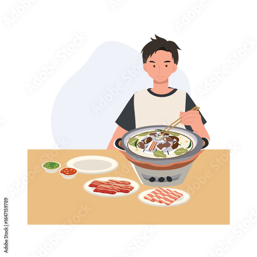 man enjoying thai barbecue moo krata hotpot with fresh meat vegetables and sauces