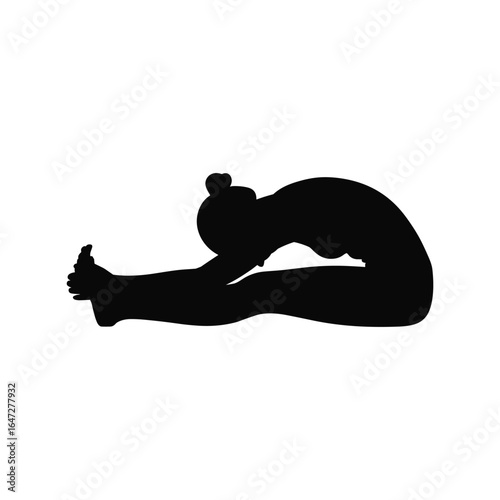 Silhouette of a woman performing a seated forward bend yoga pose